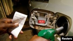 Un préposé à l'essence fait le plein d'une voiture dans une station-service à Harare, Zimbabwe, le 28 janvier 2019.