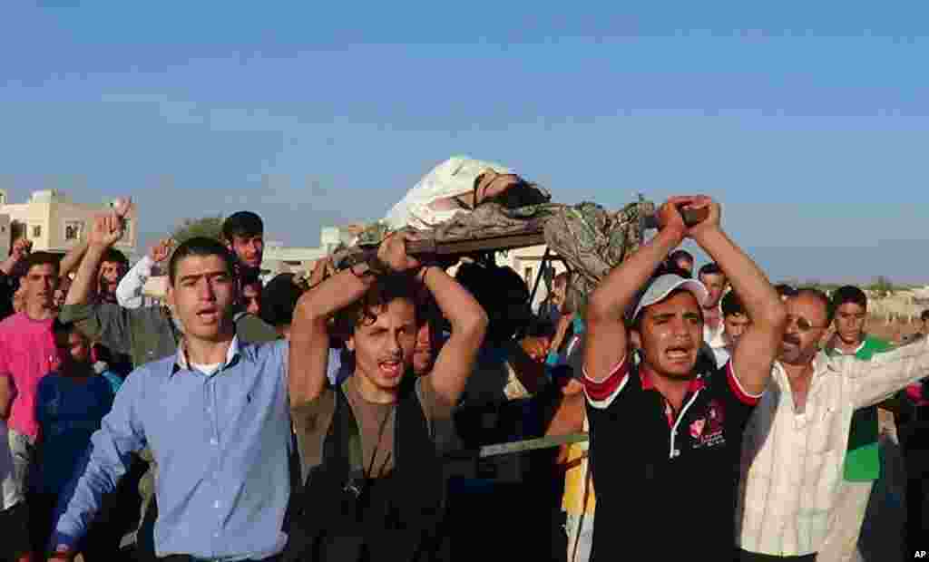 Members of the Free Syrian Army and residents carry the body of Ammar Ibrahim Reslan, whom activists said was killed by forces loyal to Syria's President Bashar al-Assad, near Idlib, October 16, 2012. 
