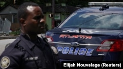 Un officier de police d'Atlanta est vu devant son véhicule à Atlanta, en Géorgie, aux États-Unis, le 18 juin 2020. 