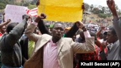 Supporters of Kenya's Opposition party Coalition for Reforms and Democracy (CORD), hold up placards ahead of a CORD rally at Uhuru Park, Nairobi, Kenya, Wednesday, Sept. 23, 2015, in solidarity with striking teachers