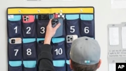 유타 주 델타고등학교의 한 9학년 학생이 수업에 들어가기 전 스마트폰을 보관시설에 넣는 모습 (자료사진)