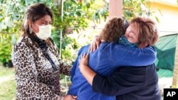 Elvira Carvajal, right, hugs Blanca Flores as Irma Durand cries after watching Joe Biden become U.S. president, Jan. 20, 2021, in Homestead, Fla. Immigrants cheered Biden's plan to provide millions without legal U.S. status a path to citizenship.
