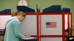FILE - Kate Irish casts her vote at the Durham County North Regional Library in Durham, N.C., May 8, 2018.