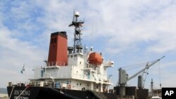 FILE - In this March 4, 2016 file photo, crewmen of the North Korean cargo vessel Jin Teng stand on the middle of the deck as it unloads its cargo while docked at Subic Bay, in Zambales province, northwest of Manila, Philippines. 