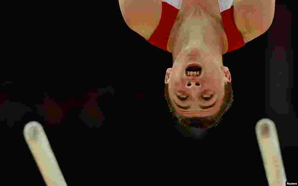 Atlet senam Inggris Sam Oldham di atas palang sejajar dalam babak kualifikasi pria di North Greenwich Arena. 