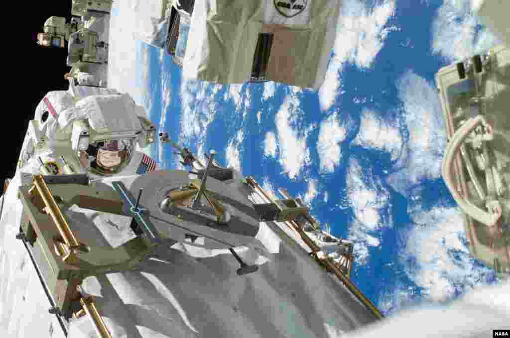 Astronot NASA Rick Mastracchio memperbaiki pompa pendingin yang rusak di Stasiun Antariksa Internasional (ISS).