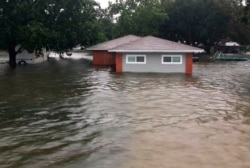 FILE - Floodwaters surround a home in Winnie, Texas, Sept. 19, 2019.
