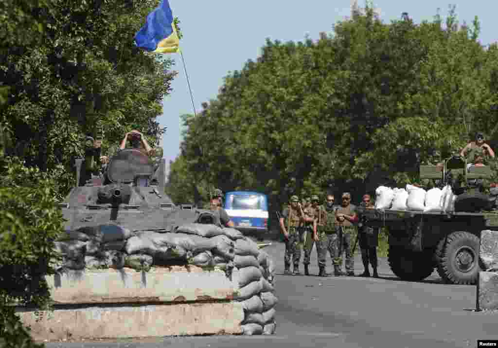 Ukrainian servicemen stand guard at a checkpoint near the town of Amvrosievka, in Donetsk region, Ukraine, June 5, 2014. 