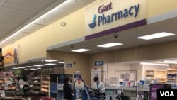 បុគ្គលិក​ធ្វើការ​នៅ​ឱសថស្ថាន​មួយ​​នៅក្នុង​ផ្សារ​ទំនើប Giant ពាក់ម៉ាស់​និយាយ​ទៅ​កាន់​អតិថិជន រដ្ឋ ម៉ារីលែន សហរដ្ឋអាមេរិក ថ្ងៃទី​១ ខែមេសា ឆ្នាំ​២០២០។