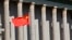 FILE- A Chinese national flag flaps in the wind outside the Great Hall of the People in Beijing.