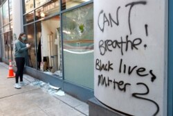 A pedestrian looks into a 7-Eleven store early Sunday morning, May 31, 2020 in Chicago, after a night of unrest and protests over the death of George Floyd, a black man who was in police custody in Minneapolis.