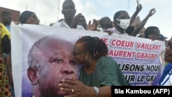 Une partisane de Laurent Gbagbo embrasse son portrait à Abidjan le 31 août 2020, lors du dépôt de son dossier de candidature à la commission électorale. (Photo by SIA KAMBOU / AFP)