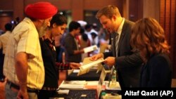 FILE - An Indian student is counseled by a representative of University of Colorado, right, during a U.S. University fair organized by EducationUSA in New Delhi, India, Saturday, November 3, 2012.