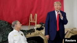 도널드 트럼프(오른쪽) 전 미국 대통령이 19일 텍사스주 에딘버그에 있는 사우스텍사스 국제공항에서 연설하는 모습을 그레그 애벗 텍사스 주지사가 바라보고 있다.