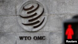 FILE - A logo is pictured outside the World Trade Organization headquarters next to a red pedestrian traffic light, in Geneva, Switzerland, Oct. 2, 2018.