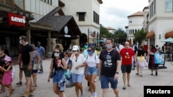 Para pengunjung pusat belanja Disney Springs di Lake Buena Vista, Florida, mengenakan masker wajah saat dibukanya kembali secara bertahap Walt Disney World setelah beberapa bulan tutup akibat pandemi Covid-19) AS 11 Juli 2020. REUTERS / Octavio Jones
