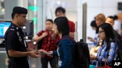 ប៉ូលិស​ម៉ាលេស៊ី​ពិនិត្យ​​ឯកសារអត្តសញ្ញាណ​អ្នក​ដំណើរ​នៅ​អាកាសយានដ្ឋាន​អន្តរជាតិ​ Kuala Lumpur International Airport កាល​ពី​ថ្ងៃ​ទី​៩​ខែ​មីនា​ឆ្នាំ​២០១៤។