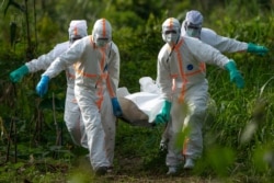 FILE - Burial workers dressed in protective gear carry the remains of an Ebola victim in Beni, DRC, July 14, 2019.