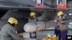 资料照片：台湾嘉义一个空军基地的地勤人员在一架F-16战机的机翼上安装导弹。（2023年1月6日）