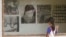 FILE - A Cambodian girl looks at images of Khmer Rouge victims at Tuol Sleng genocide museum, formerly the regime's notorious S-21 prison in Phnom Penh, Cambodia, March 26, 2015.
