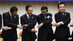 From left: South Korea's President Lee Myung-bak, China's Premier Wen Jiabao, Cambodia's Prime Minister Hun Sen and Japan's Prime Minister Yoshihiko Noda prepare to join hands together for a group photo during the ASEAN Plus Three (APT) Commemorative Summit in Phnom Penh, Cambodia, Monday, Nov. 19, 2012. (AP Photo/Vincent Thian)