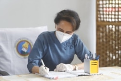FILE - Daw Aung San Suu Kyi, Myanmar's de facto leader, fills out a ballot in her country's election in Naypyitaw, Oct. 29, 2020.