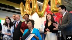District of Columbia Mayor Muriel Bowser, seated, holds the LOVE Act she signed, joined by soon to be newlyweds, Claire O'Rourke, left and her fiancé Sam Bockenhauer; Caitlin Walters, back left, and her fiance Kirk Kasa; and Danielle Geanacopoulos. Photo from January 11, 2019. 