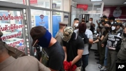 Four police officers wanted in connection with the death of a suspect in their custody arrive at the Nakhon Sawan police station for interrogations in Nakhon Sawan province, Thailand, Aug. 25, 2021.