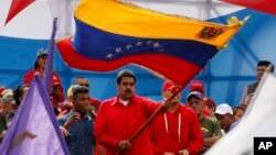Venezuela's President Nicolas Maduro waves the Venezeulan flag during a rally in Caracas, Venezuela, July 27, 2017. Maduro has provoked international outcry and enraged an opposition demanding his resignation with his push to elect an assembly that will r