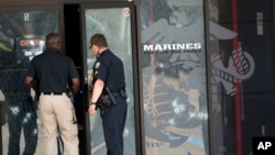 Police officers enter the Armed Forces Career Center through a bullet-riddled door after a gunman opened fire on the building in Chattanooga, Tennessee, July 16, 2015.