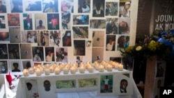 Candles and flowers decorate an altar for massacre victims during a memorial in the La Saline slum of Port-au-Prince, Haiti, Dec. 13, 2018. 