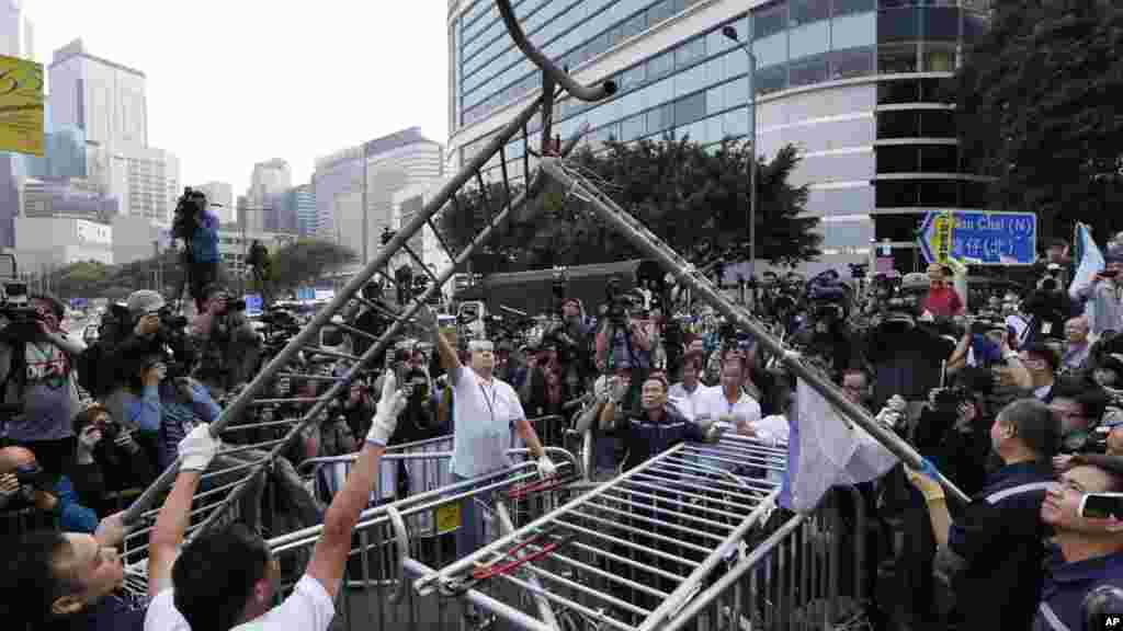 Workers start clearing away barricades at an occupied area outside government headquarters in Hong Kong, Nov. 18, 2014. 