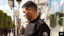 A Tunisian policeman wears a red armband showing solidarity with the demonstrators in Tunis, Tunisia, 22 Jan 2011