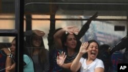 Para tahanan politik melambaikan tangan untuk mengekspresikan kegembiraan atas pembebasan dari penjara Helicoide di Caracas, Venezuela, Jumat, 1 Juni 2018. 