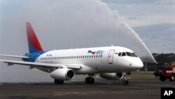 Sebuah truk pemadam kebakaran menyambut kedatangan Sukhoi Superjet 100 dengan menyemprotkan air ke badan pesawat tersebut setibanya di bandara Halim Perdanakusumah, Jakarta (28/2). Satu dari 12 armada Sukhoi Superjet 100 milik maskapai Sky Aviation telah tiba di Indonesia, sembilan bulan pasca jatuhnya pesawat jenis ini di gunung Salak.