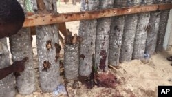 Un résident de Grand-Bassam montre un impact de balle près de l'hôtel Nouvelle Paillote, le 14 mars 2016, lendemain de l'attaque terroriste. (AP Photo/Christin Roby)