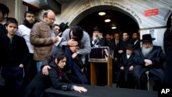 Family and relatives of Yoav Hattab, a Jewish victim of the attack on a kosher grocery store in Paris, gather around a symbolic coffin for his funeral procession in the city of Bnei Brak near Tel Aviv, Israel, Jan. 13, 2015. 