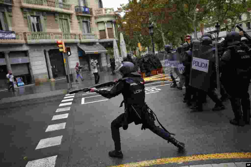 Spanish riot police shoots rubber bullets straight to people trying to reach a voting site at a school assigned to be a polling station by the Catalan government in Barcelona, Oct. 1, 2017.