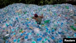 ឯកសារ៖ កម្មករ​ម្នាក់​ប្រើ​ខ្សែ​ដើម្បី​ទាញ​​នៅ​ក្នុងគំនរ​ដប​ជ័រ​នៅ​ទី​ក្រុង Mumbai ប្រទេស​ឥណ្ឌា កាល​ពី​ឆ្នាំ​២០១៤។