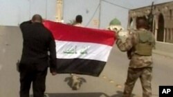 ទាហាន​អ៊ីរ៉ាក់​លើក​ទង់ជាតិ​អ៊ីរ៉ាក់​នៅ​លើ​អគារ​មួយ បន្ទាប់​ពី​មាន​ការ​ប្រកាស​ថា ក្រុង​ Fallujah ត្រូវ​បាន​រំដោះ​ទាំងស្រុង។ 