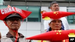 រូបឯកសារ៖ បាតុករ​ពាក់​មួយ​ក្រដាស​មាន​រូប​ទូក​និង​រូប​មីស៊ីល​បែប​កំប្លែង ប្រមូលផ្តុំ​គ្នា​នៅ​ស្ថានកុងស៊ុល​ចិន​ ដើម្បី​ប្រឆាំង​នឹង​ការ​ដាក់​យោធា​​ចិន​នៅ​សមុទ្រ​ដែល​មាន​ជម្លោះ កាល​ពី​ខែ​កុម្ភៈ នៅ​ទីក្រុង​ម៉ានីល ប្រទេស​ហ្វីលីពីន។