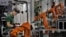 FILE - A man works amid orange robot arms at Rapoo Technology factory in southern Chinese industrial boomtown of Shenzhen. The country's trade with North Korea has slowed for the second consecutive year. 