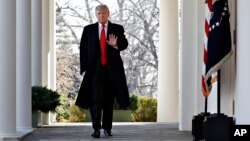FILE - President Donald Trump waves as he walks through the Colonnade from the Oval Office of the White House on arrival to make an announcement.