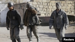 FILE - Miners are seen walking at one of the coal mines of the state-owned Longmay Group on the outskirts of Jixi, in Heilongjiang province, China, Oct. 24, 2015.