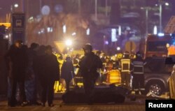 Stručnjaci su se okupili kraj prekrivenih tijela ubijenih ljudi u blizini koncertne dvorane Crocus City Hall nakon incidenta s pucnjavom, izvan Moskve, Rusija, 23. ožujka 2024.