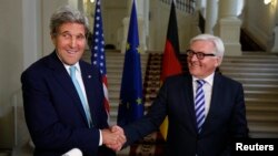 Menteri Luar Negeri AS John Kerry (kiri) dan Menteri Luar Negeri Jerman Frank-Walter Steinmeier berjabat tangan setelah selesai memberikan pernyataan pada media di Wina, Austria, 13 Juli 2014. 