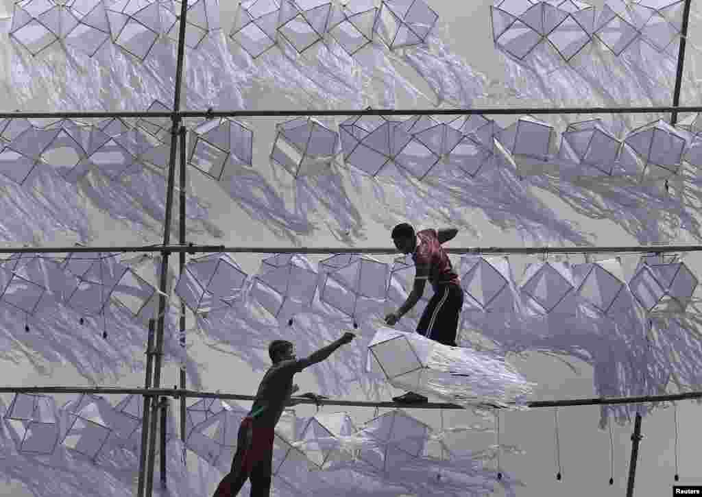 Dua orang pria memasang lentera Waisak menjelang Hari Raya Waisak di Kolombo, Sri Lanka.