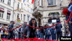 Sejumlah warga meletakkan bunga-bunga sebagai penghormatan terhadap para korban ledakan bom pada Minggu (13 November 2022) di Istiklal Avenue, tempat populer bagi warga setempat dan turis di Istanbul, Turki, 14 November 2022. (Foto: Umit Bektas/Reuters)