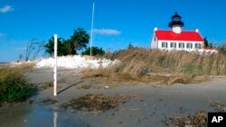In this Nov. 10, 2018, file photo, water from the Delaware Bay approaches the East Point Lighthouse in Maurice River Township, N.J. Rising seas and erosion are threatening lighthouses around the world, including the East Point Lighthouse.