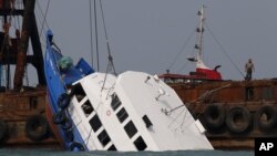 Petugas tengah memeriksa kondisi kapal feri yang tenggelam dekat Pulau Lamma, lepas pantai baratdaya Hong Kong, 2 Oktober 2012 (Foto: dok). Kapten kapal feri tersebut, Lai Sai-ming, dijatuhi hukuman penjara delapan tahun (16/2), atas kelalaiannya mengemudikan kapal, dan mengakibatkan tewasnya 39 penumpang.